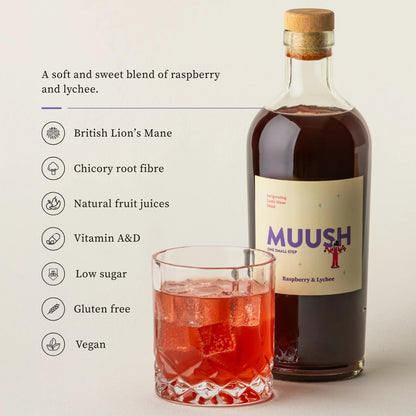 Bottle of Muush raspberry and lychee drink with a glass of red liquid on a light background