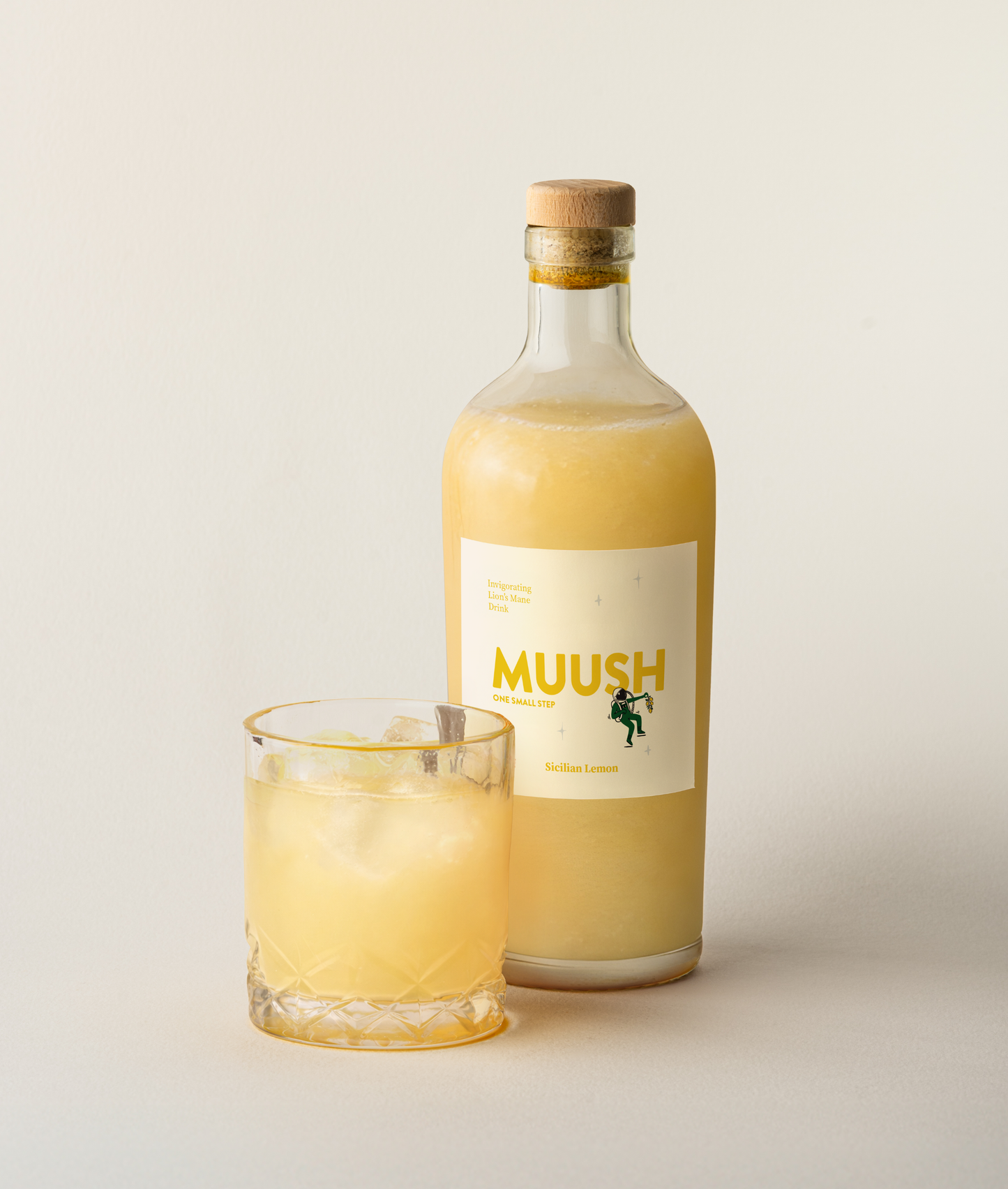 Bottle and glass of MUUSH SICILIAN LEMON ELIXIR drink on a light background