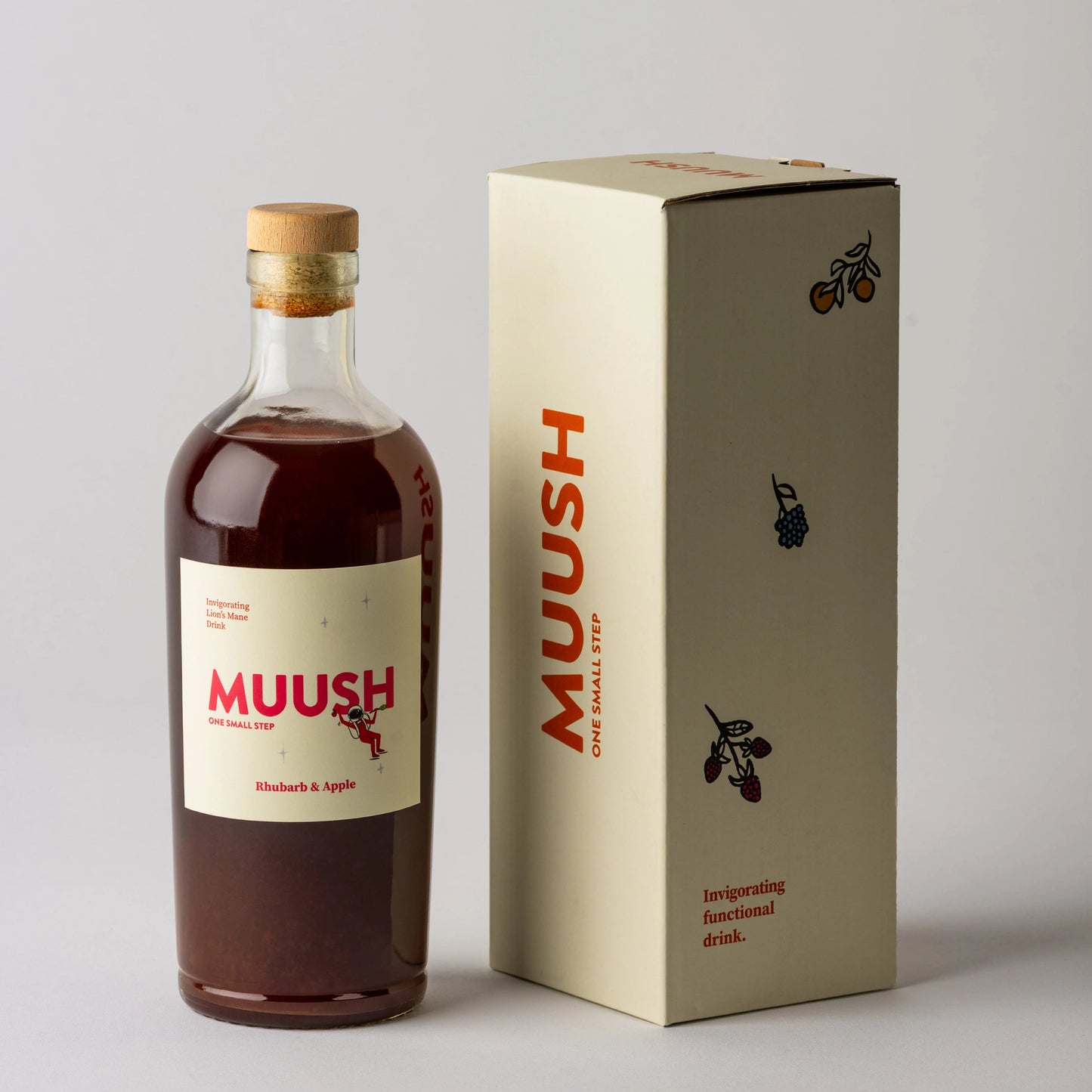 Bottle and box of Muush Rhubarb and apple on a gray background