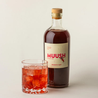 Bottle of MUUSH RHUBARB & APPLE
 Elixir bottle with a glass of RHUBARB & APPLE flavoured spritz.