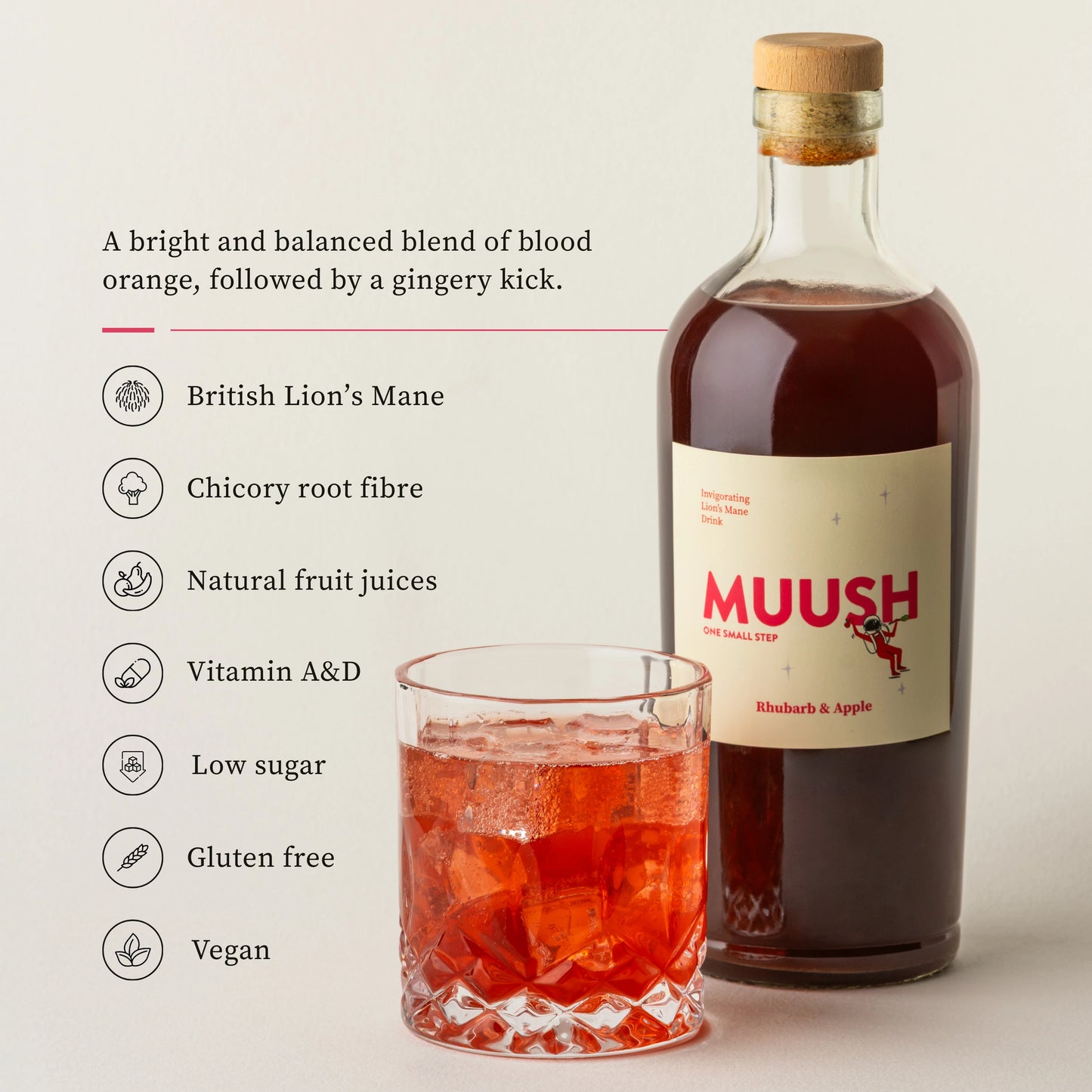 Bottle of Muush rhubarb and apple with a glass of red liquid on a light background
